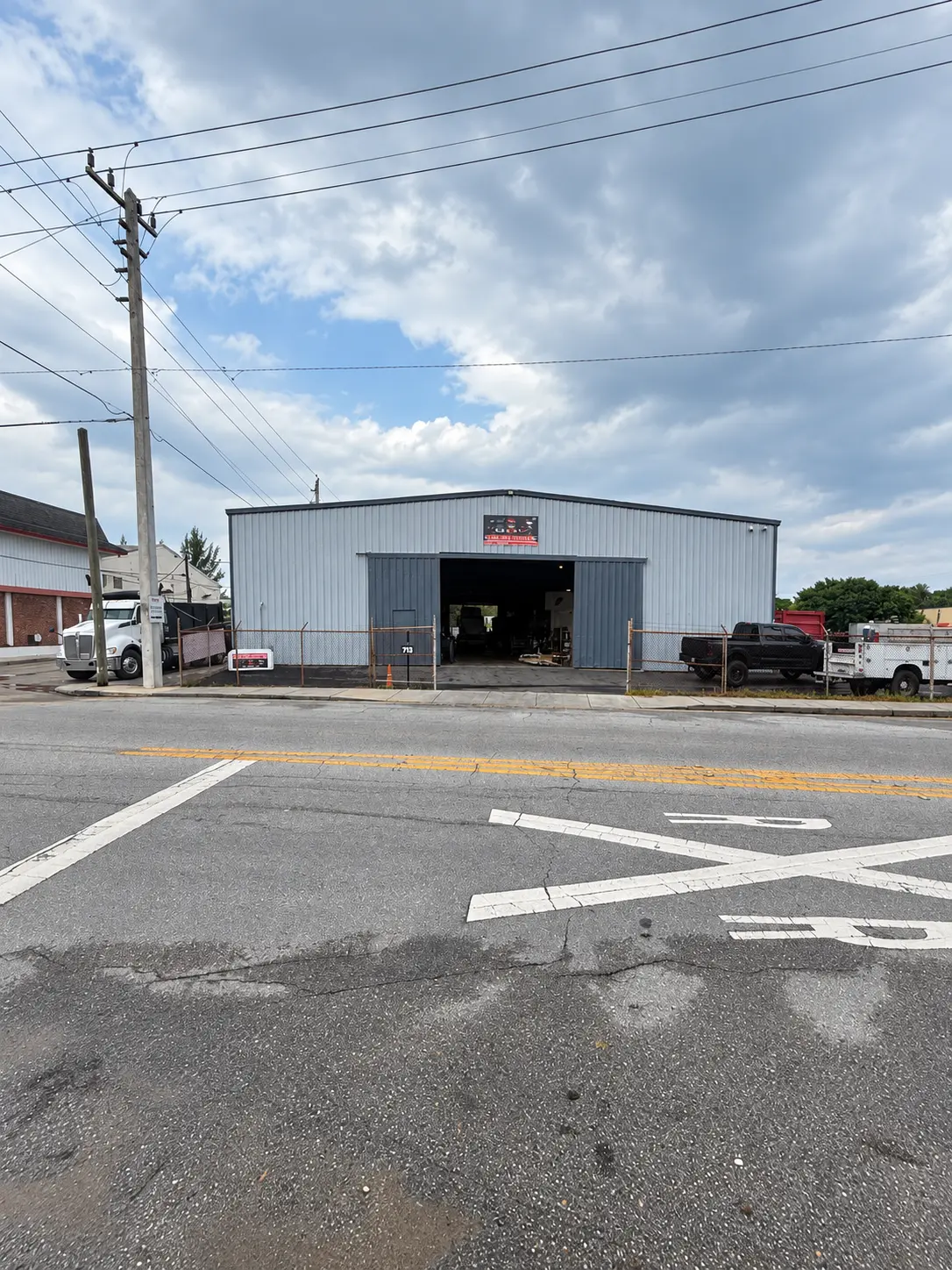 Big Boy Truck Services' shop building with its bay doors open, seen from the street
